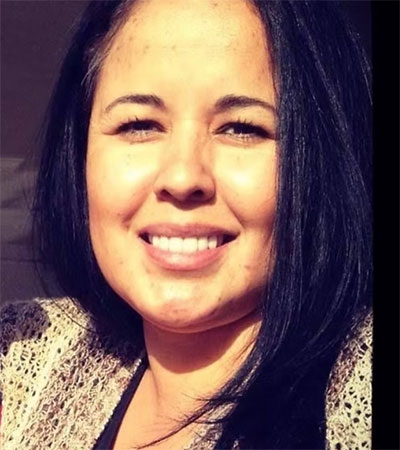 A woman with short hair and a smile looking at the camera.