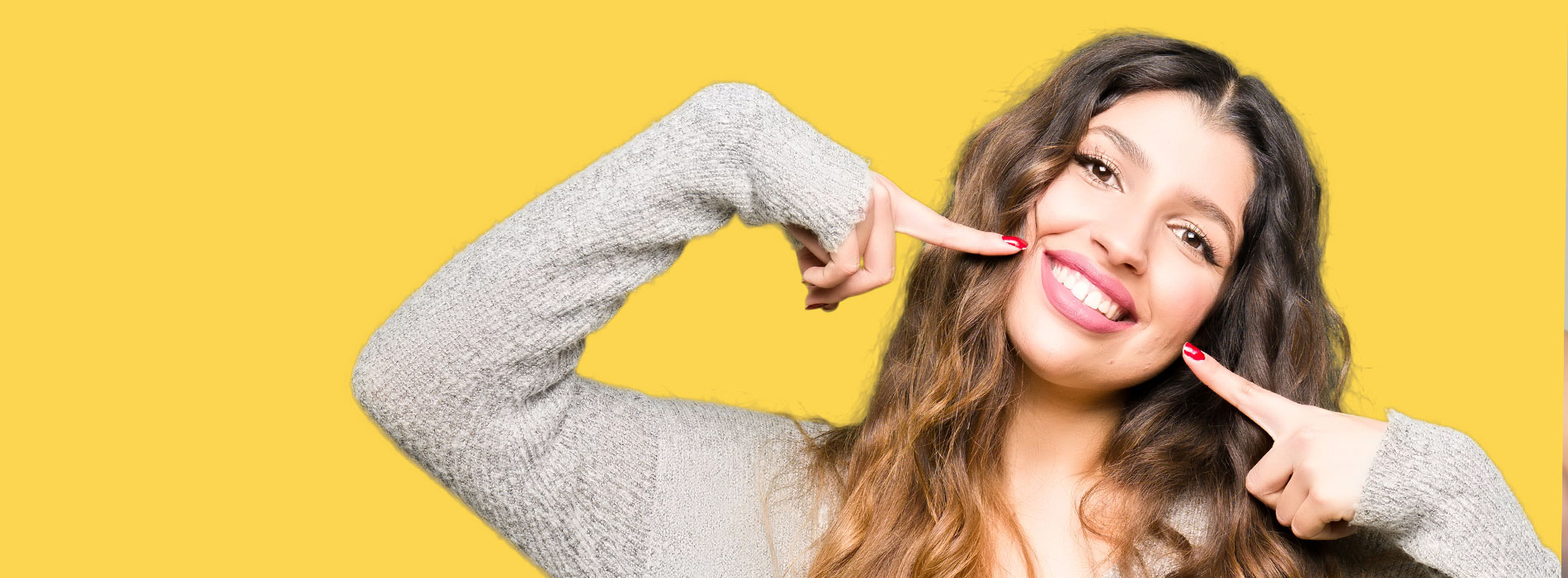 A well-lit reception area with a desk, computer monitor, and potted plant.